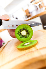 Image showing Woman's hands cutting kiwi