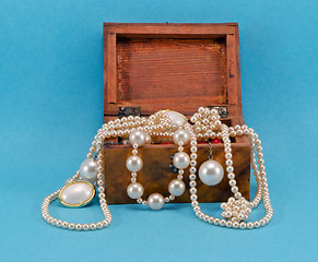 Image showing Pearl jewelry in retro wooden box on blue 