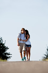 Image showing young woman and man is walking on a road in summer outdoor