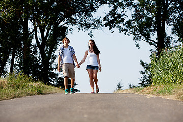 Image showing young woman and man is walking on a road in summer outdoor