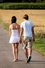 Image showing young woman and man is walking on a road in summer outdoor