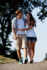 Image showing young woman and man is walking on a road in summer outdoor