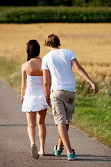 Image showing young woman and man is walking on a road in summer outdoor