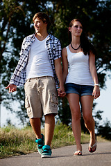 Image showing young woman and man is walking on a road in summer outdoor