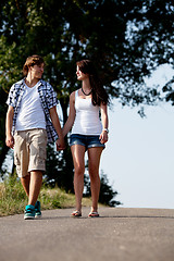 Image showing young woman and man is walking on a road in summer outdoor