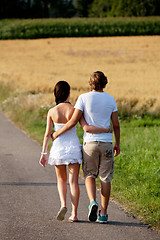 Image showing young woman and man is walking on a road in summer outdoor