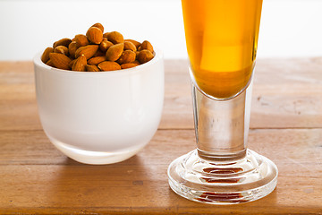 Image showing Bowl of raw almond nuts on wooden table