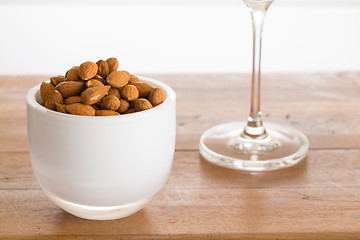 Image showing Bowl of raw almond nuts on wooden table