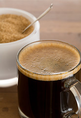 Image showing Black coffee and froth in glass mug with sugar