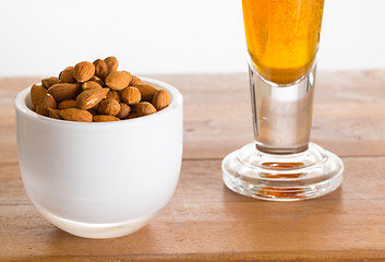 Image showing Bowl of raw almond nuts on wooden table