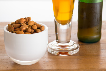 Image showing Bowl of raw almond nuts on wooden table