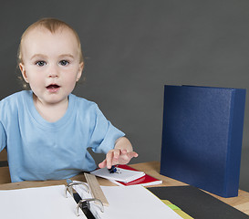 Image showing child with paperwork at small desk