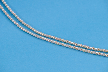 Image showing Pearl necklace fragment closeup on blue background 