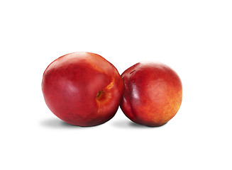 Image showing two nectarines with green leaves over white background