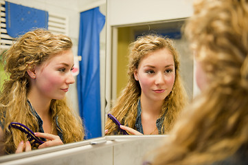 Image showing pretty teenager combing her hair