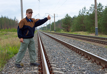 Image showing Elderly man on railway with the lifted hand