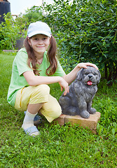 Image showing Smiling little girl near to concrete dog