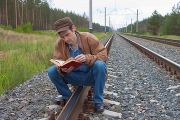 Image showing Man sits on railway and with reads 