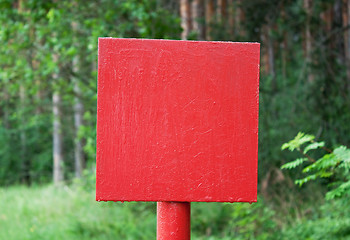 Image showing Red metal plate in wood