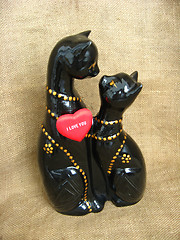 Image showing Two toy enamoured cats on a brown background