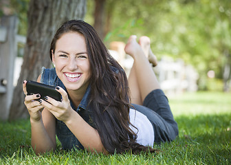 Image showing Mixed Race Young Female Texting on Cell Phone Outside