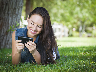 Image showing Mixed Race Young Female Texting on Cell Phone Outside