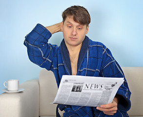 Image showing Person reads a newspaper with pensiveness