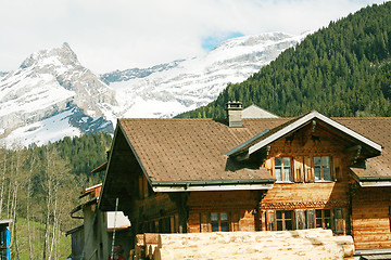 Image showing Lovely Swiss chalet with mountains in background 