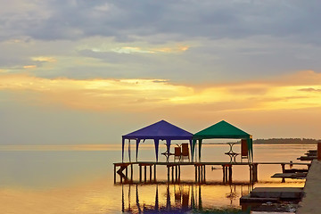 Image showing Tents above sea water at sunset