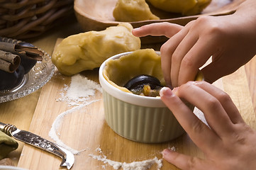 Image showing Detail of child hands making plum tart