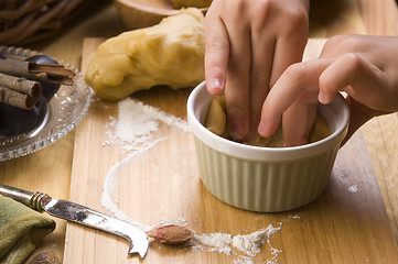 Image showing Detail of child hands making plum tart