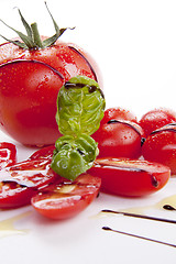 Image showing fresh red tomatoes with balsamic and oilve oil isolated