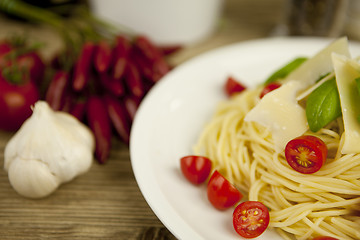 Image showing fresh tasty pasta with tomato and basil on table