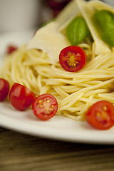 Image showing fresh tasty pasta with tomato and basil on table