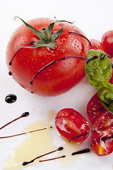 Image showing fresh red tomatoes with balsamic and oilve oil isolated