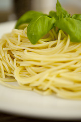 Image showing tasty fresh pasta with garlic and basil on table