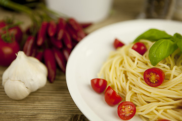 Image showing fresh tasty pasta with tomato and basil on table