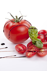 Image showing fresh red tomatoes with balsamic and oilve oil isolated