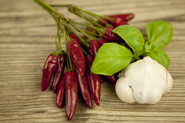 Image showing red hot chilli pepper with basil and garlic on table