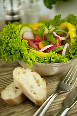 Image showing fresh tasty healthy mixed salad and bread on table