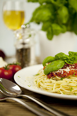 Image showing delicious fresh spaghetti with tomato sauce and parmesan on table