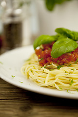 Image showing delicious fresh spaghetti with tomato sauce and parmesan on table