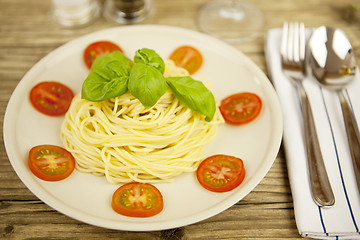 Image showing fresh tasty pasta with tomato and basil on table