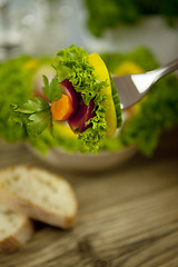 Image showing fresh tasty healthy mixed salad and bread on table