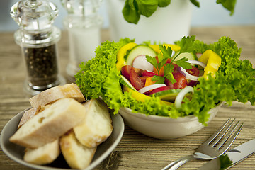 Image showing fresh tasty healthy mixed salad and bread on table