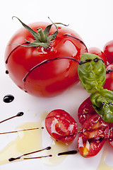 Image showing fresh red tomatoes with balsamic and oilve oil isolated