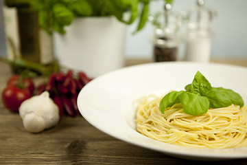 Image showing tasty fresh pasta with garlic and basil on table