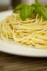 Image showing tasty fresh pasta with garlic and basil on table