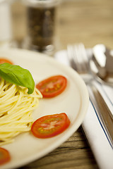 Image showing fresh tasty pasta with tomato and basil on table