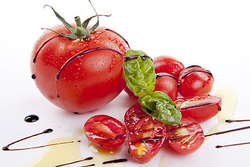 Image showing fresh red tomatoes with balsamic and oilve oil isolated